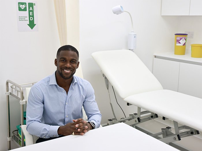 a picture of a private gp london doctor smiling in his clinic